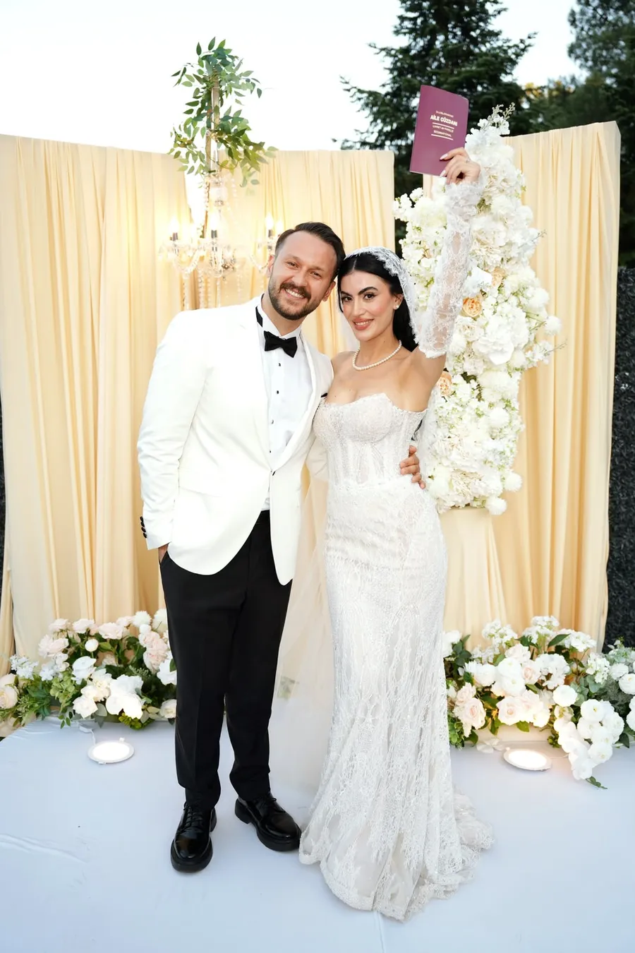 Çiçekli fon önünde nikah sonrası çift